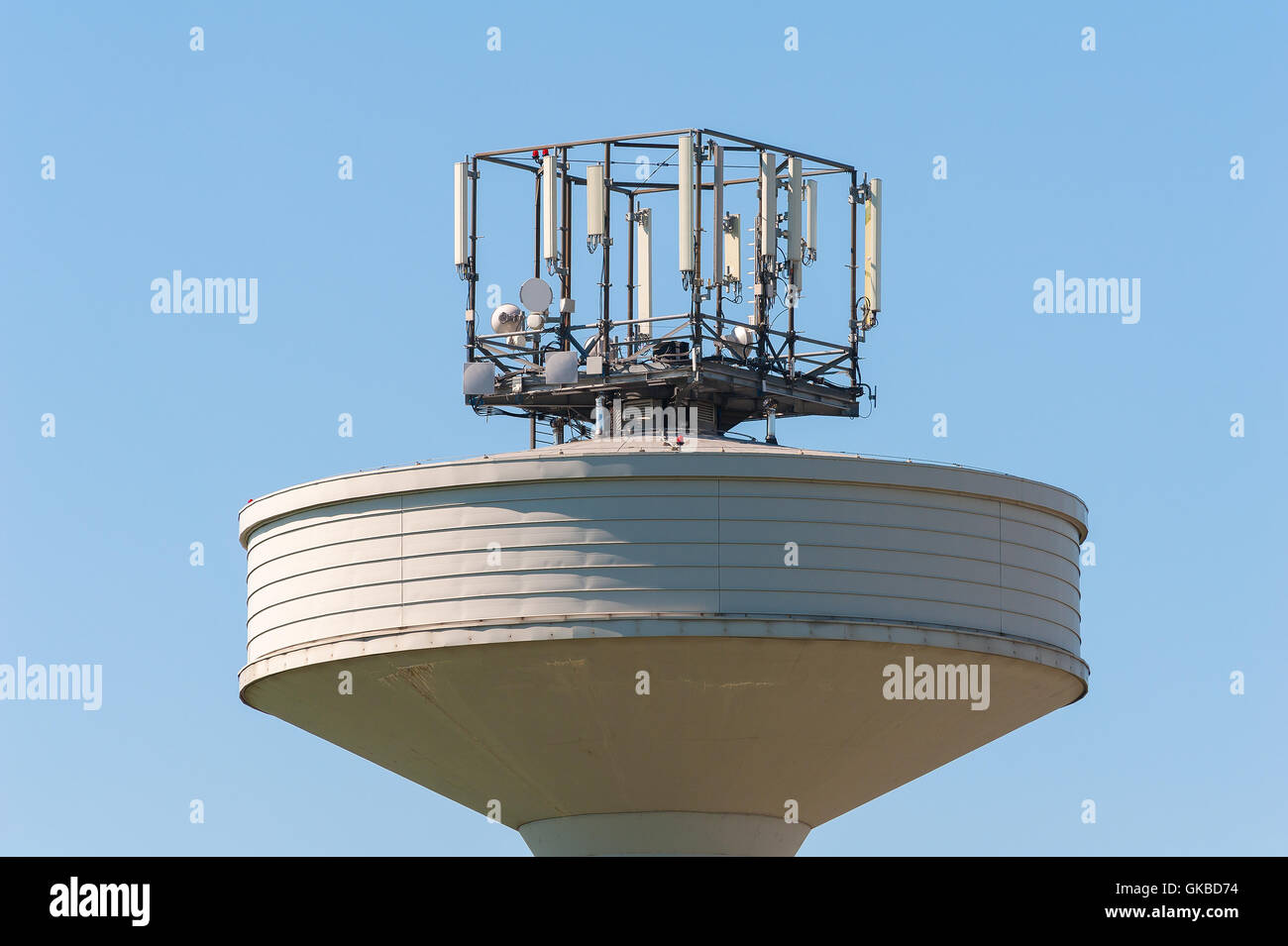 Wasser Tank Turm überragt mit einer Telefon-Repeater-Antennen gegen il Cielo Blu. Textfreiraum Stockfoto
