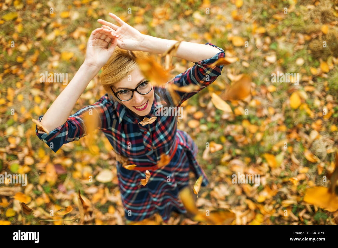 Junge Mädchen tanzen unter fallenden Blätter im Herbst park Stockfoto
