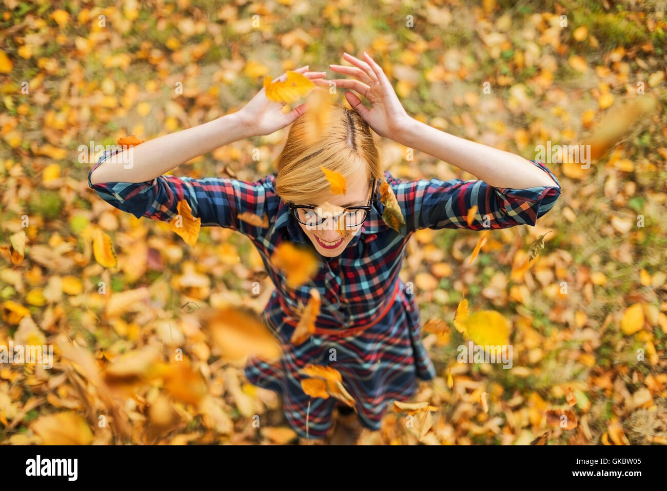 Junge Mädchen tanzen unter fallenden Blätter im Herbst park Stockfoto