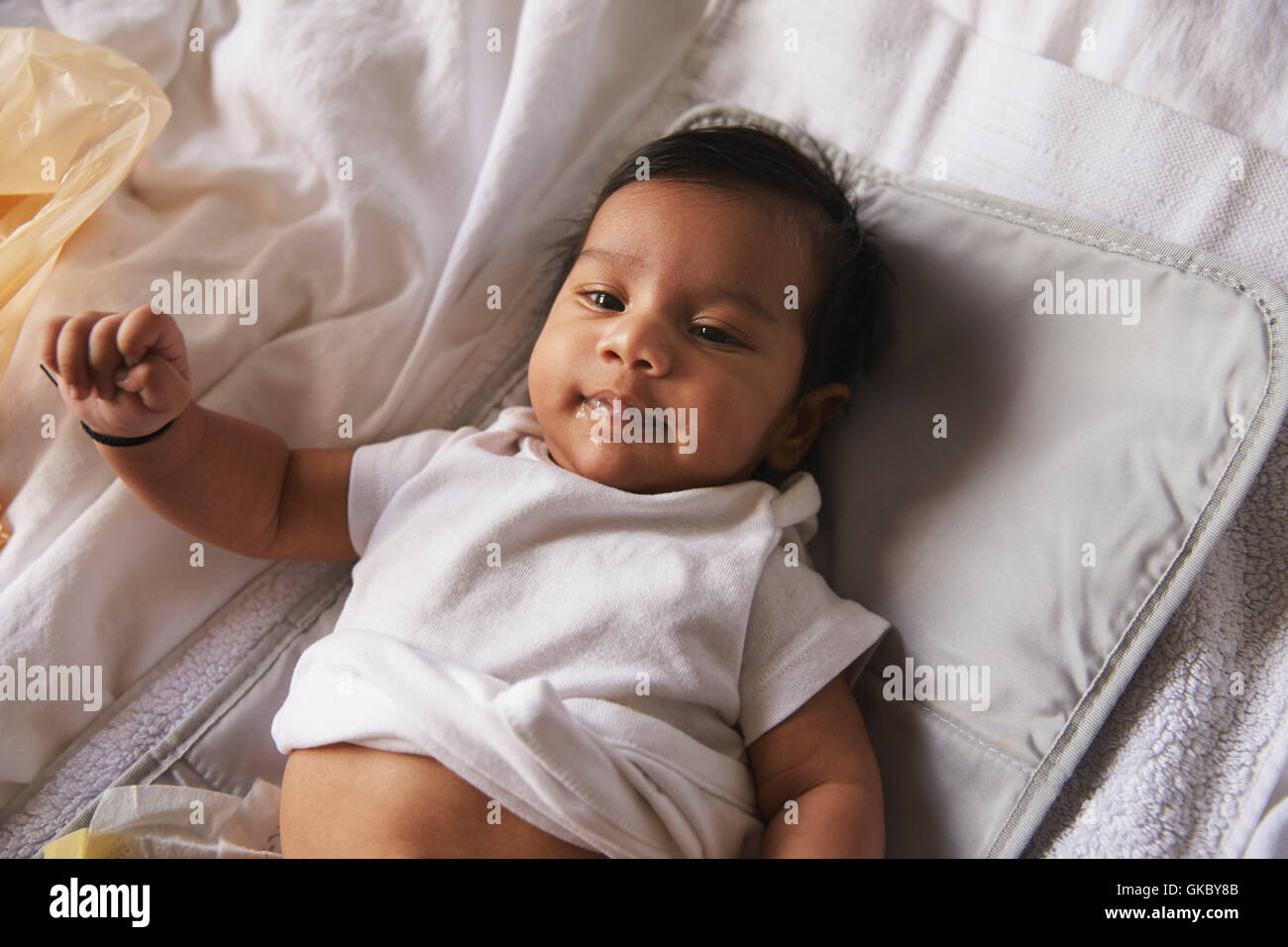 Blick hinunter auf glückliches Baby Boy Wickelauflage liegend Stockfoto