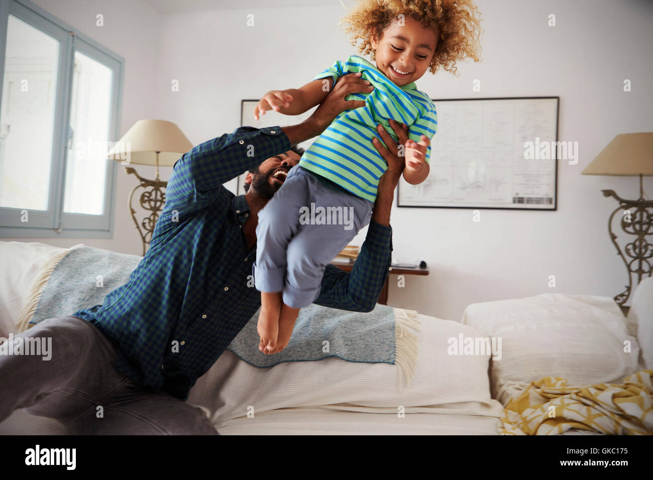 Vater und Sohn zusammen Spiel auf Sofa Stockfoto