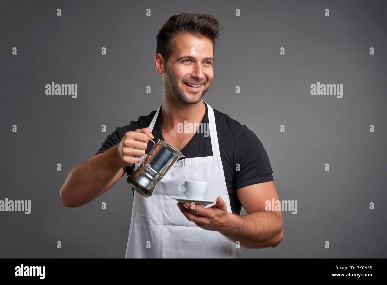 Ein junger Barista Mann lächelnd und gießen Kaffee aus einer Kaffeemaschine, einem coffeecup Stockfoto