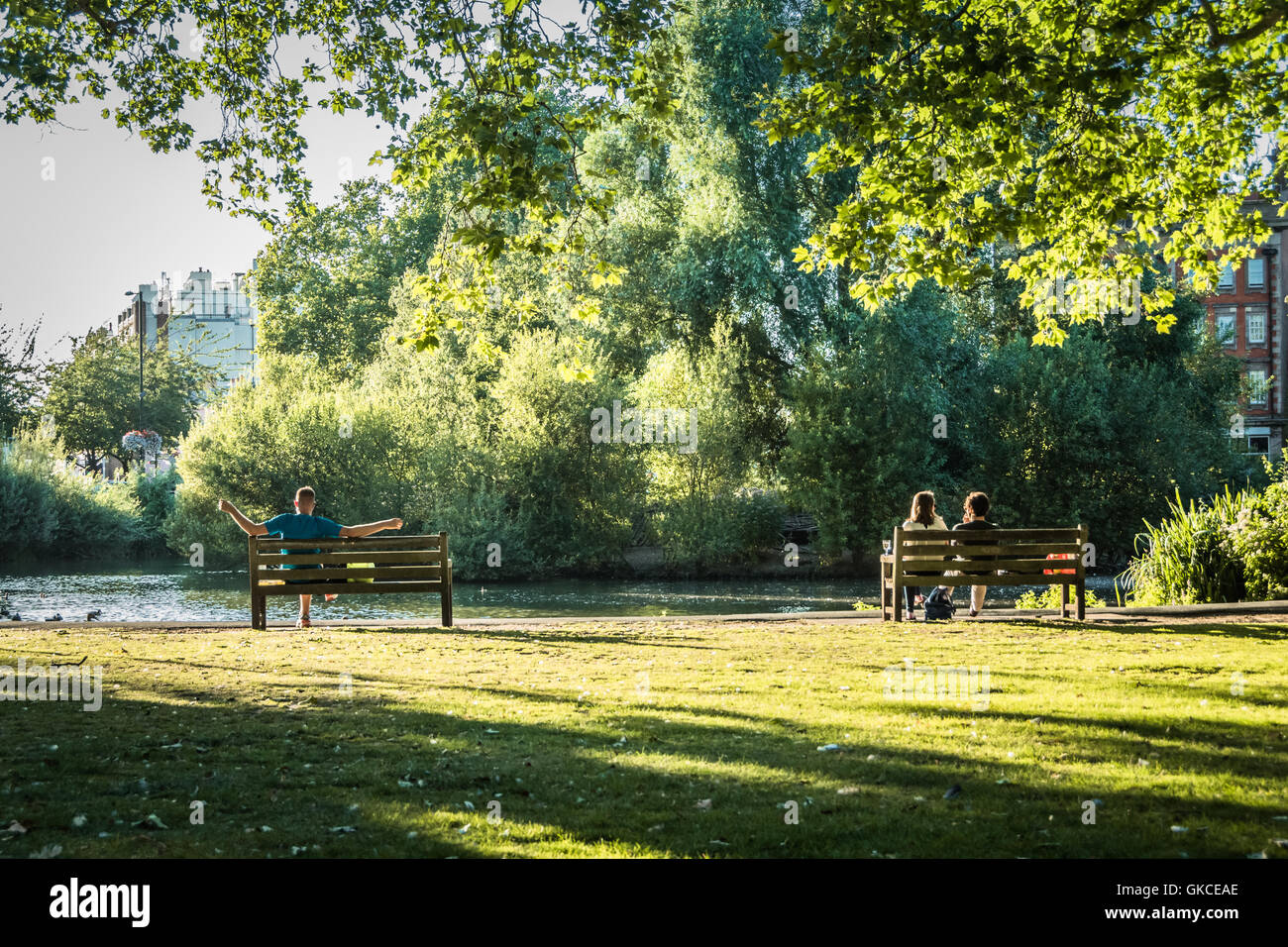Menschen entspannen in der Sommersonne neben Barnes Teich im Zentrum von London Stockfoto