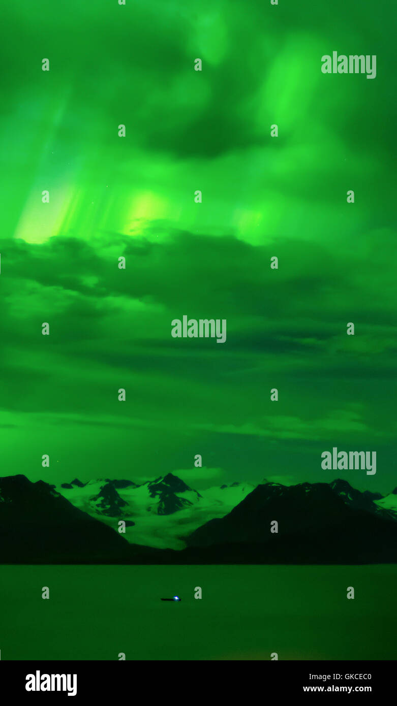 Ein Polarlicht füllt den Nachthimmel mit ein grünes Leuchten und leuchtet Grewingk Gletscher und Kachemak Bay. Stockfoto