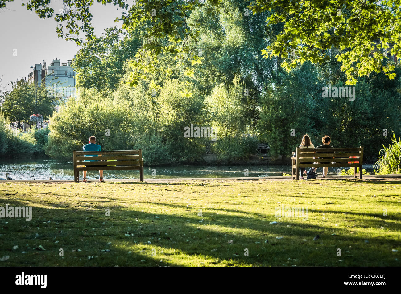 Menschen, die sich in der Sommersonne neben dem Barnes Pond im Südwesten Londons, England, Großbritannien, entspannen Stockfoto