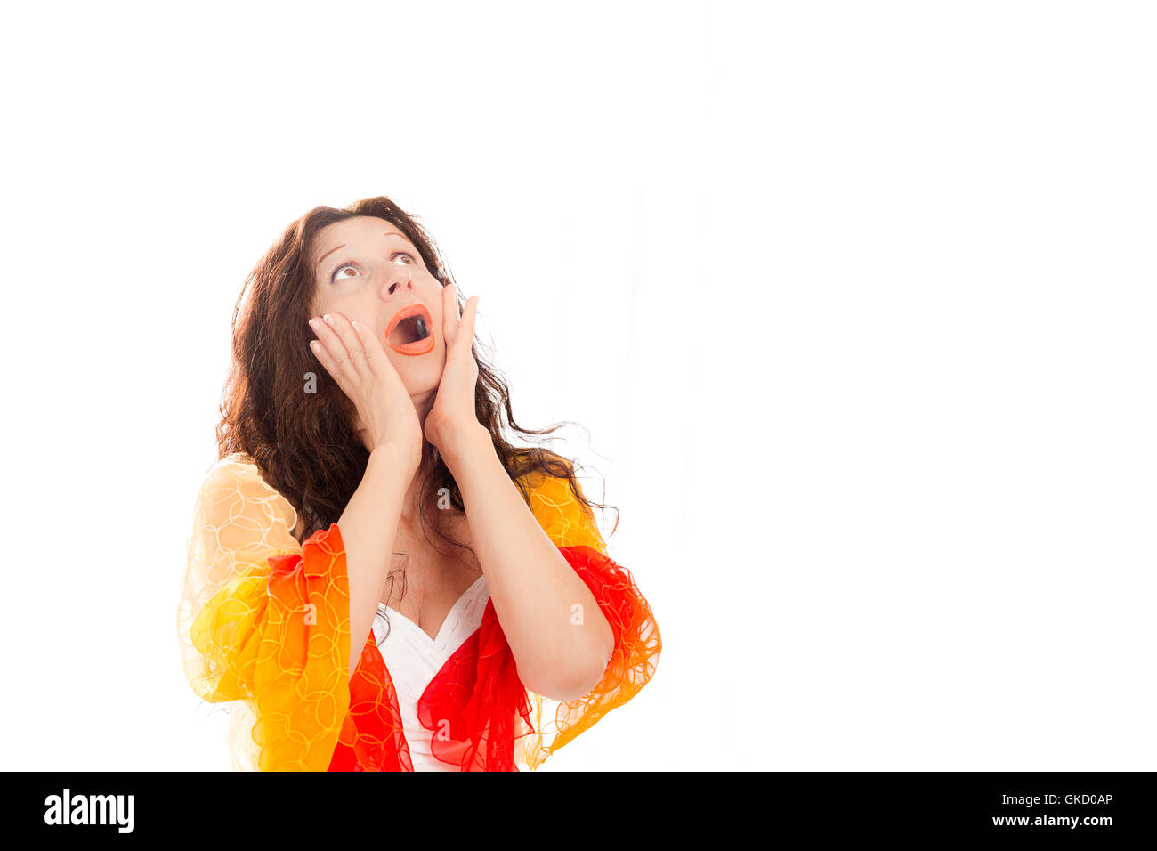 Schockiert Erwachsene mediterrane Frau mit offenem Mund halten, Hände auf die Wangen und auf der Suche nach oben isoliert auf weißem Hintergrund Stockfoto