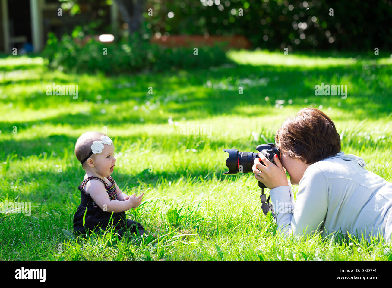 Baby Fotograf mit professionellen Kamera-Ausrüstung machen ein Foto-Shooting für ein 6 Monate altes Mädchen. Stockfoto