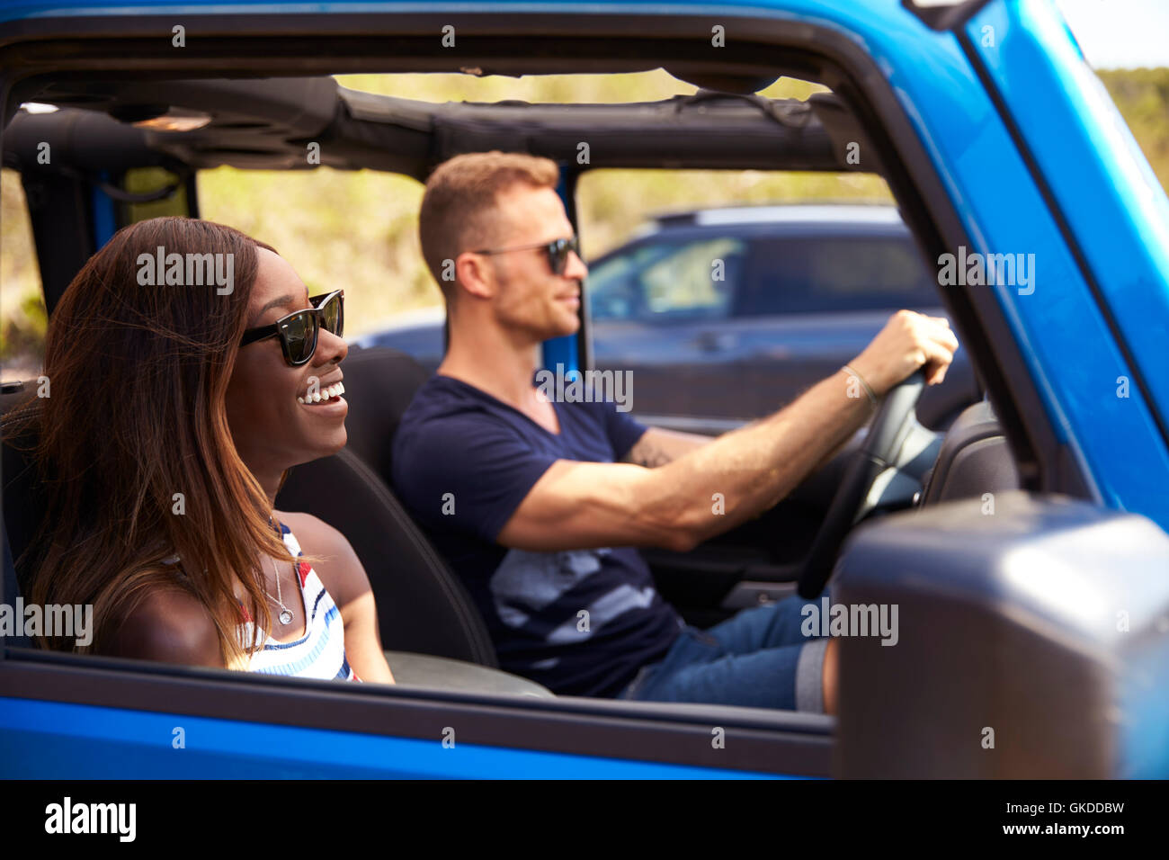 Junges Paar fahren Open Top Car auf Landstraße Stockfoto