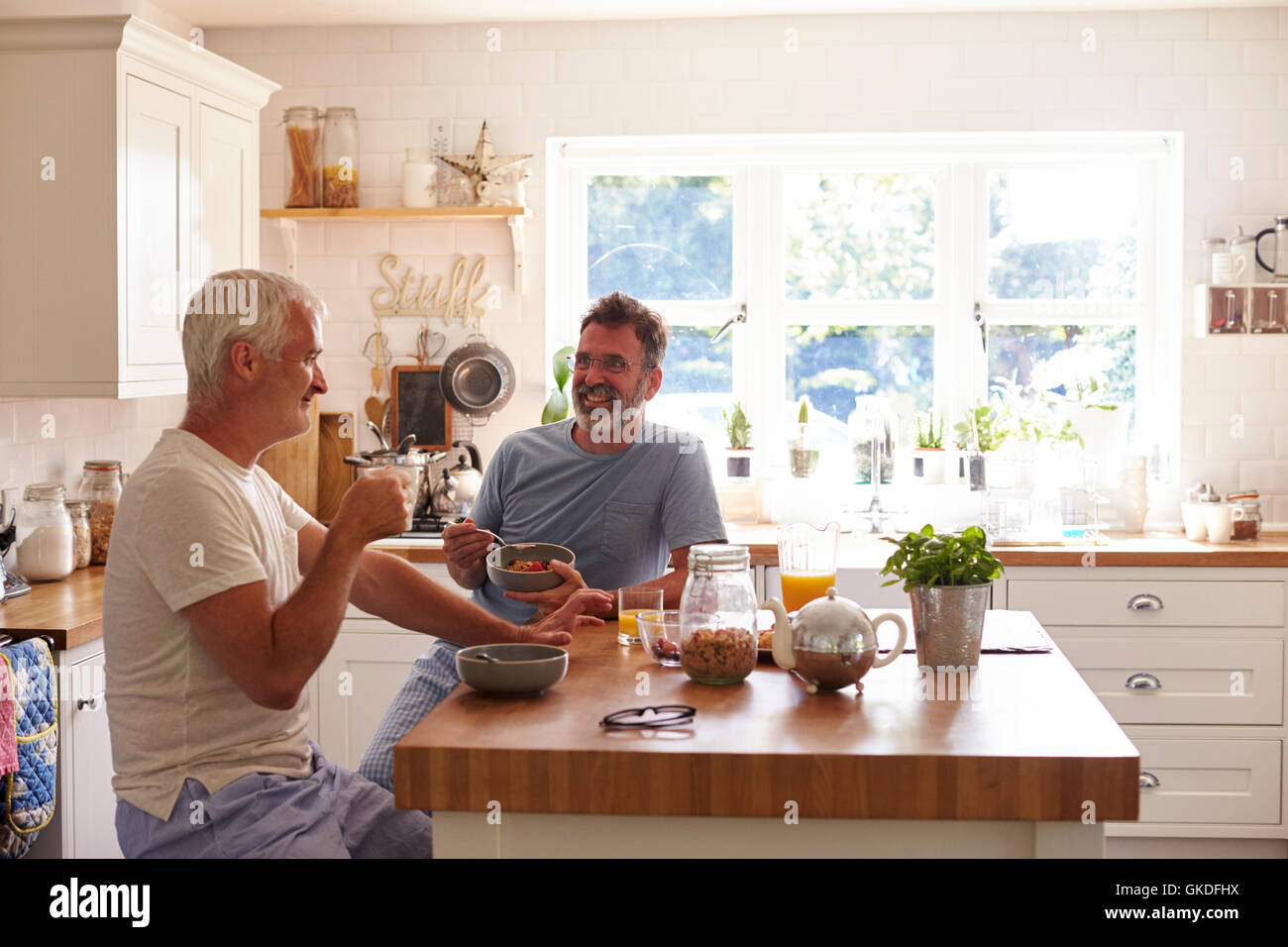 Applying männlichen schwules Paar im Gespräch über das Frühstück zu Hause Stockfoto