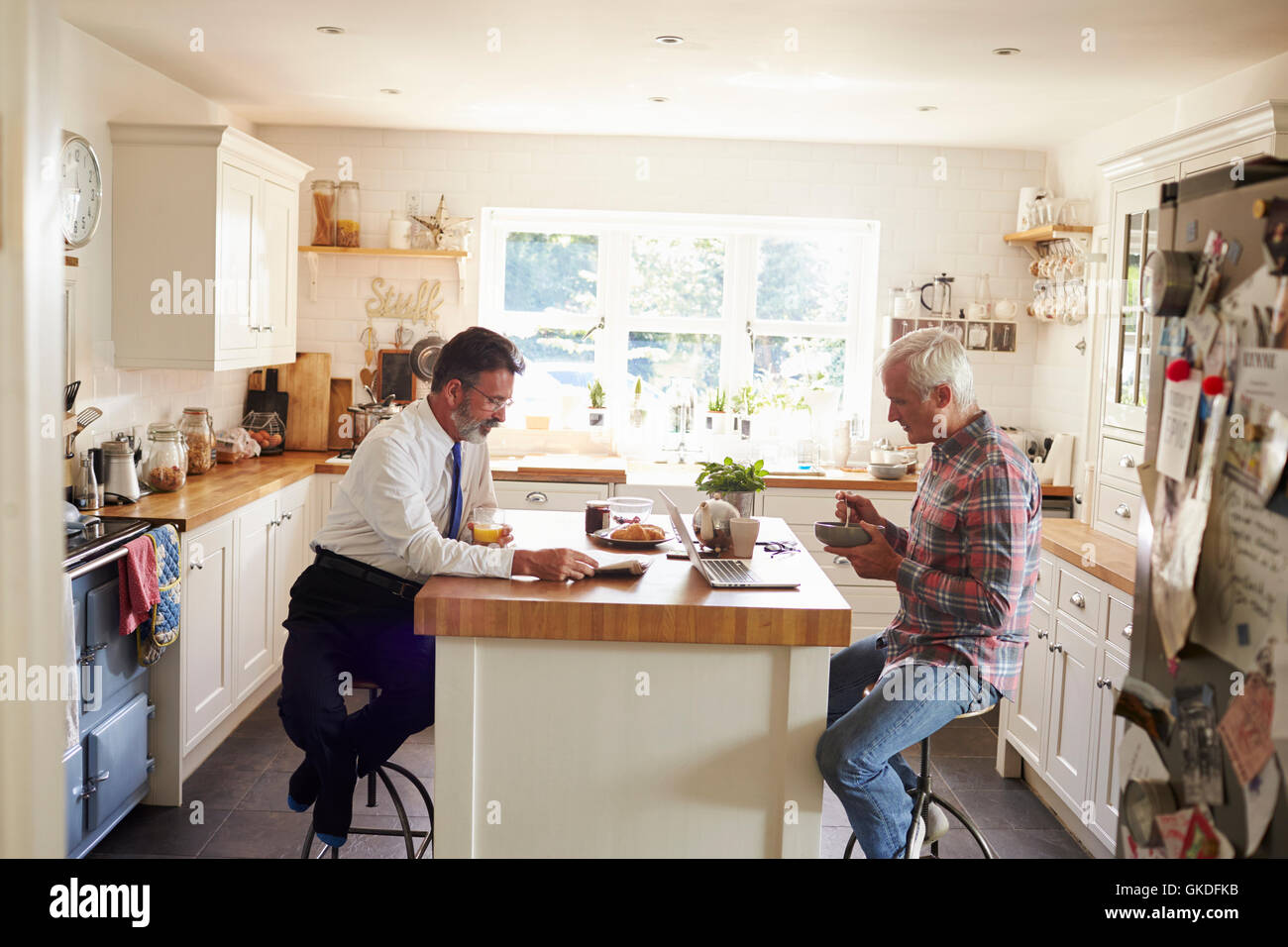 Männliche Paare, Frühstück am Kücheninsel vor arbeiten Stockfoto