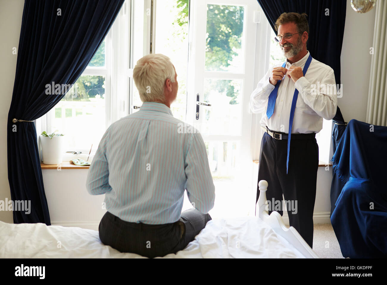 Männliche paar küssen im Schlafzimmer vor der Arbeit, vom Eingang Stockfoto