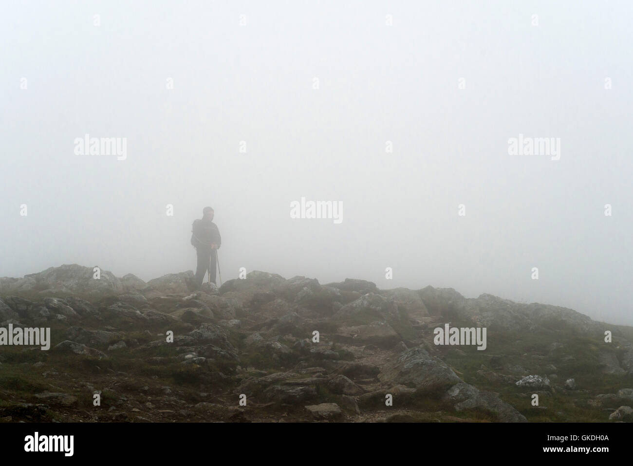 Mann, stehend in niedrigen Wolken mit schlechter Sicht auf Ben Vorlich (Loch earn) Stockfoto