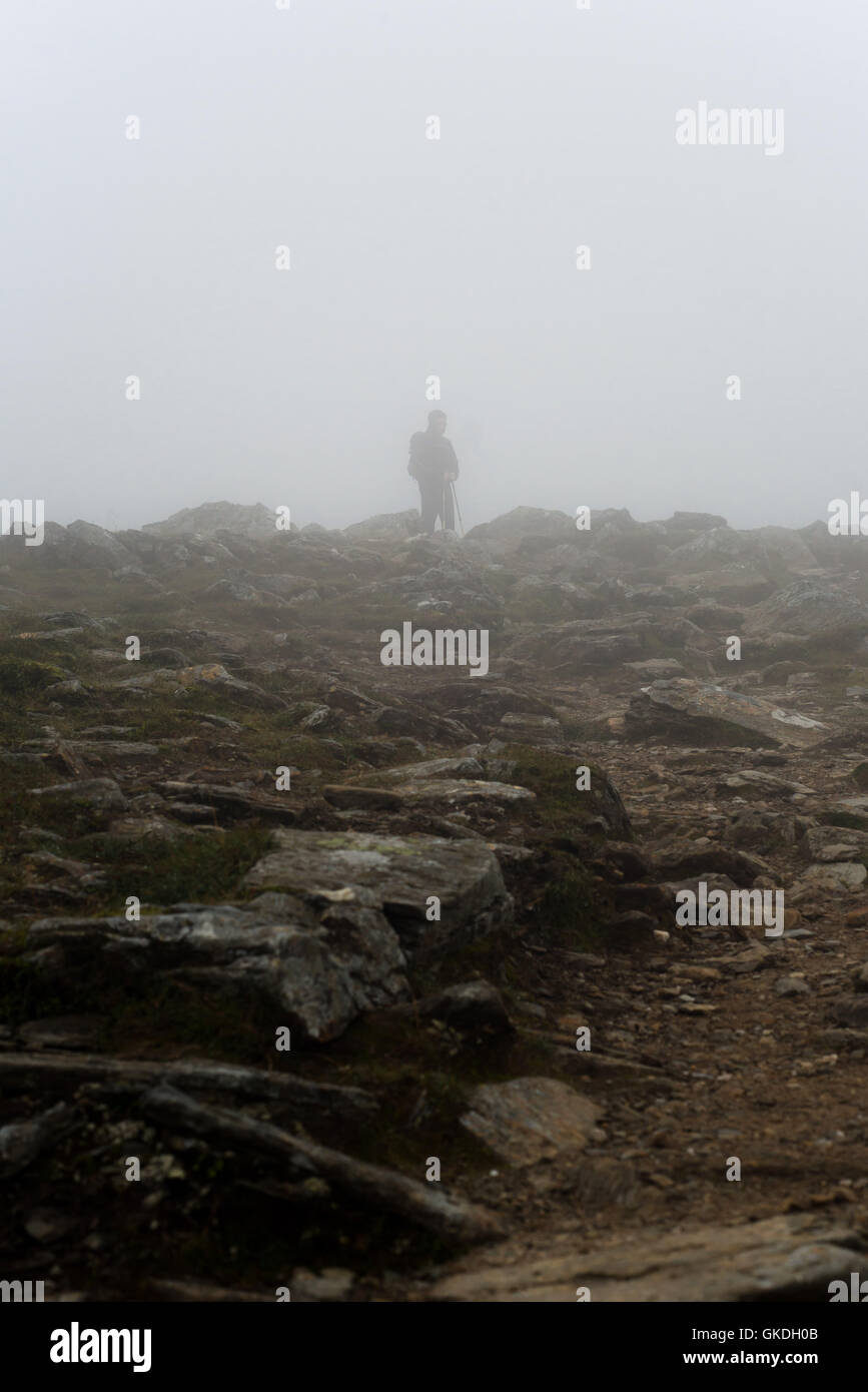 Mann, stehend in niedrigen Wolken mit schlechter Sicht auf Ben Vorlich (Loch earn) Stockfoto