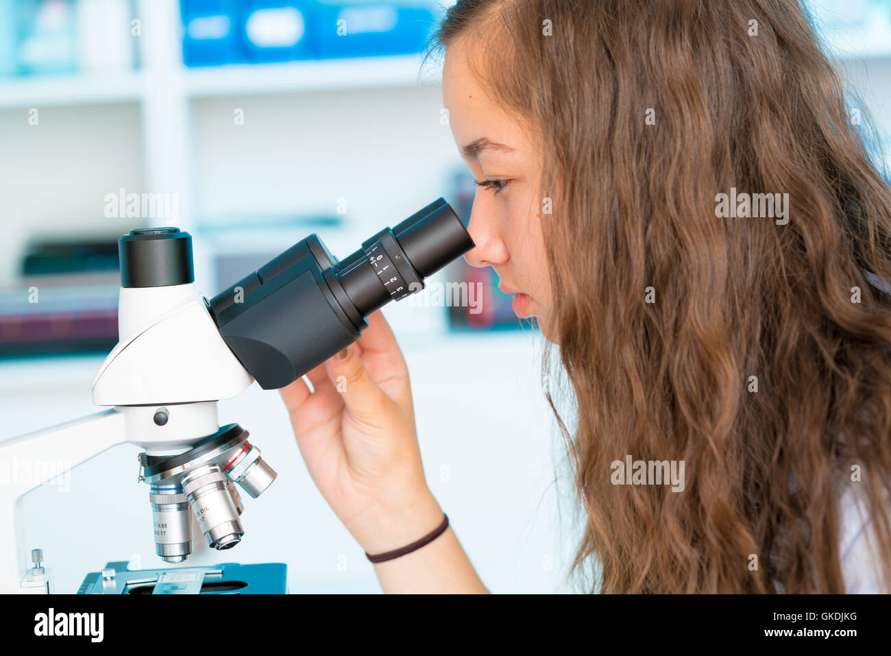 Junge Frau Schülerarbeiten im mikrobiologischen Labor mit Mikroskop Stockfoto