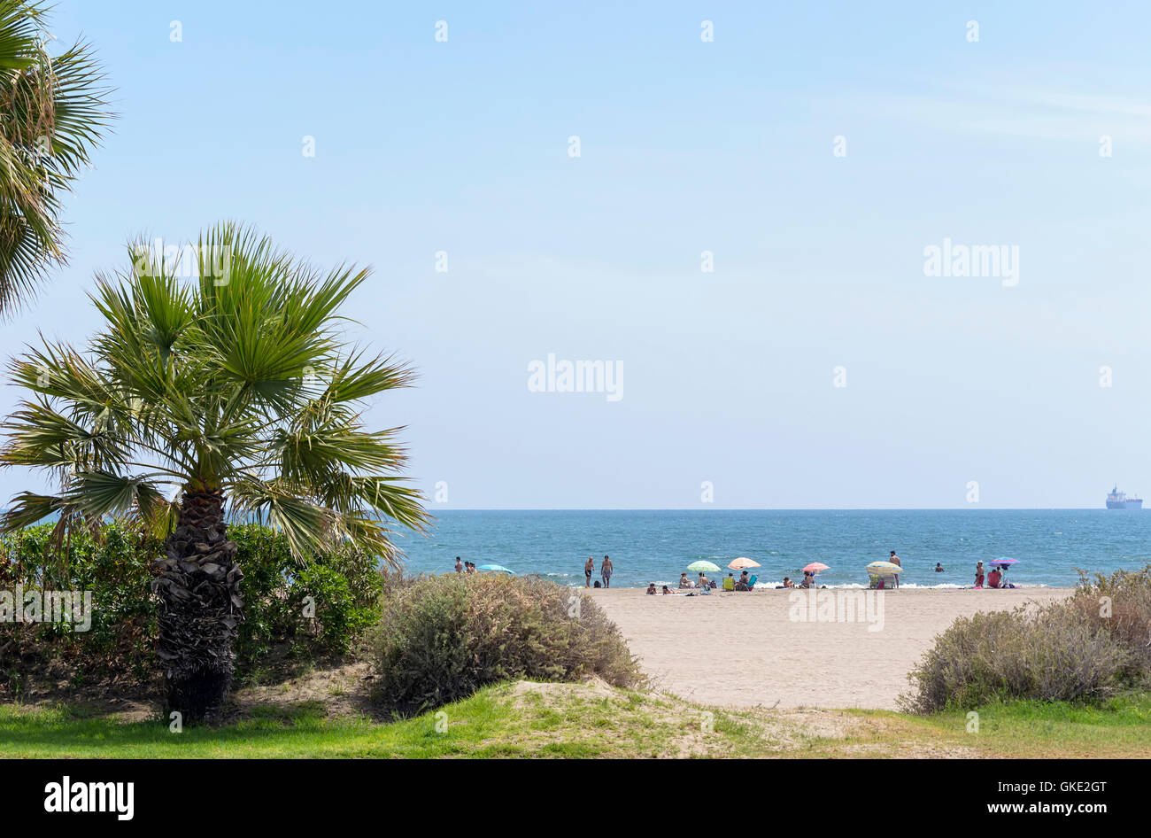 Sonnenstrand-Tag in der Sommersaison. Menschen genießen, Sonnenbaden, Schwimmen, mit Blick auf den Horizont, der Ozean, Boote... Stockfoto