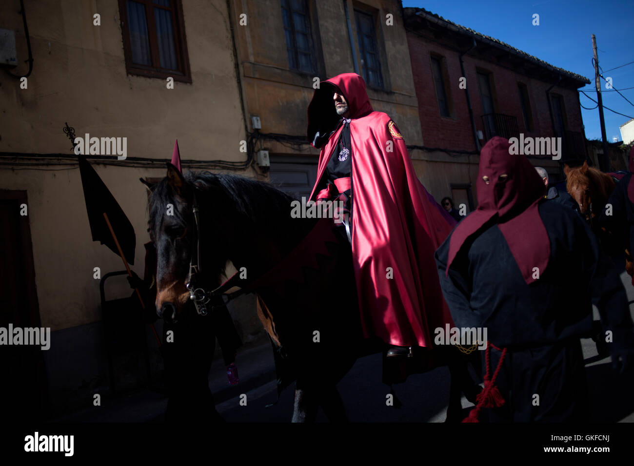 Ein Mann trägt einen Umhang mit Kapuze reitet auf einem Pferd während einer Prozession der Karwoche in Astorga, Castilla y Leon, Spanien. Stockfoto