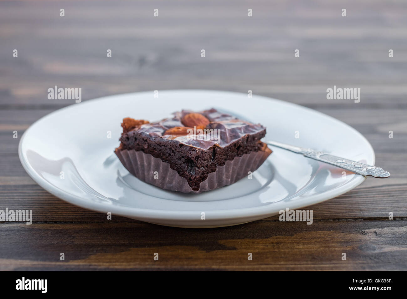 Hausgemachte Schokoladen-Brownie mit Mandel und Löffel in weißen Schale auf Holztisch. Stockfoto