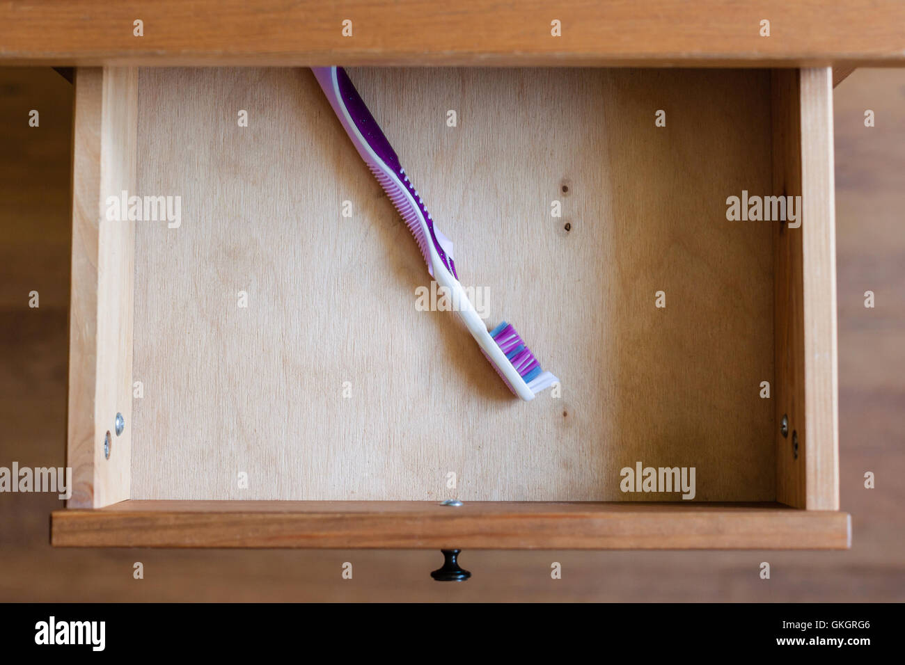 über Blick auf moderne Zahnbürste in offene Schublade des Nachttisch Stockfoto