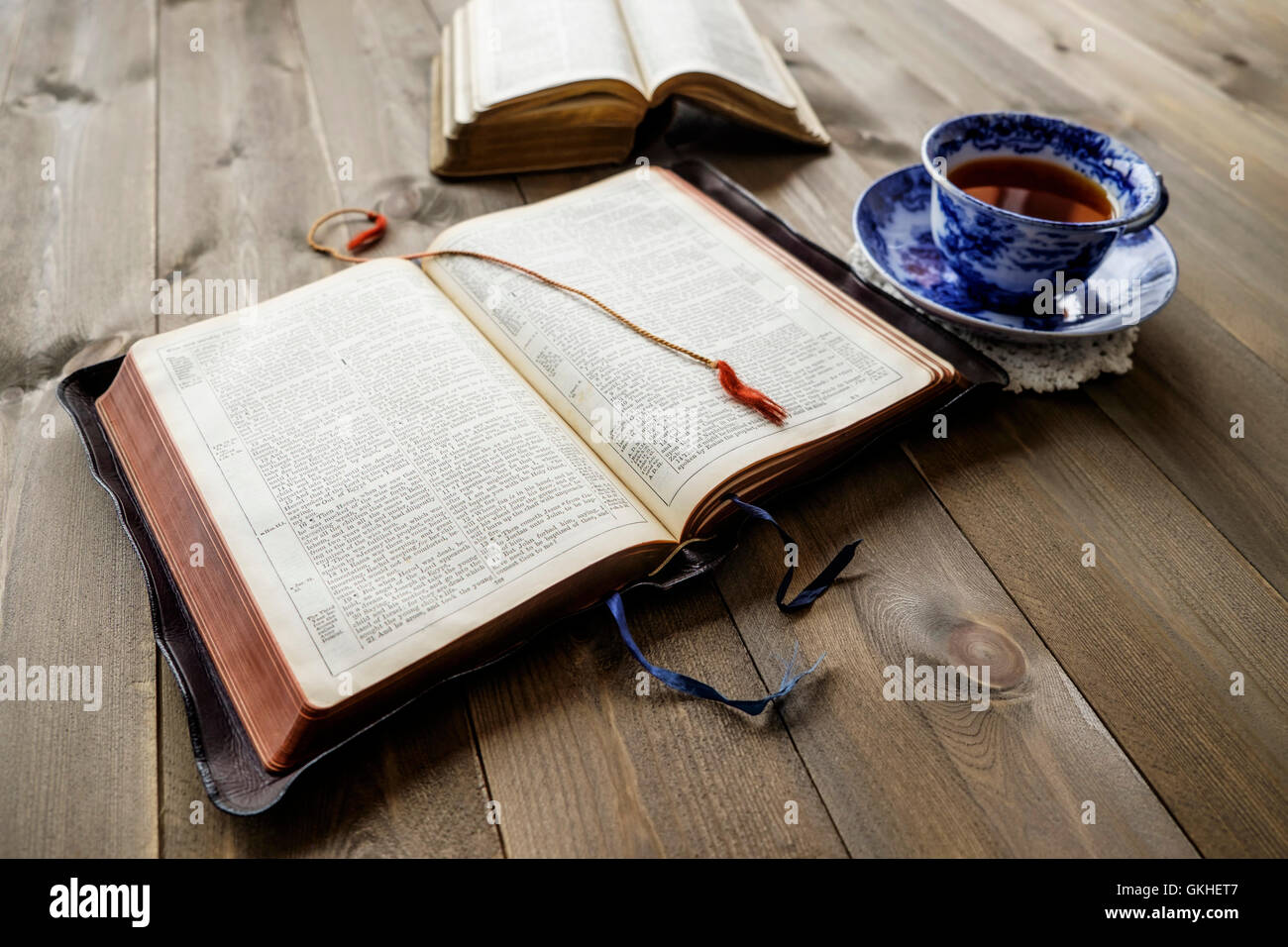 Friedliche christlichen religiösen Szene von zwei offenen Bibeln mit Tasse Tee auf Holztisch Hintergrund. Bibeln sind nicht Marke versi Stockfoto
