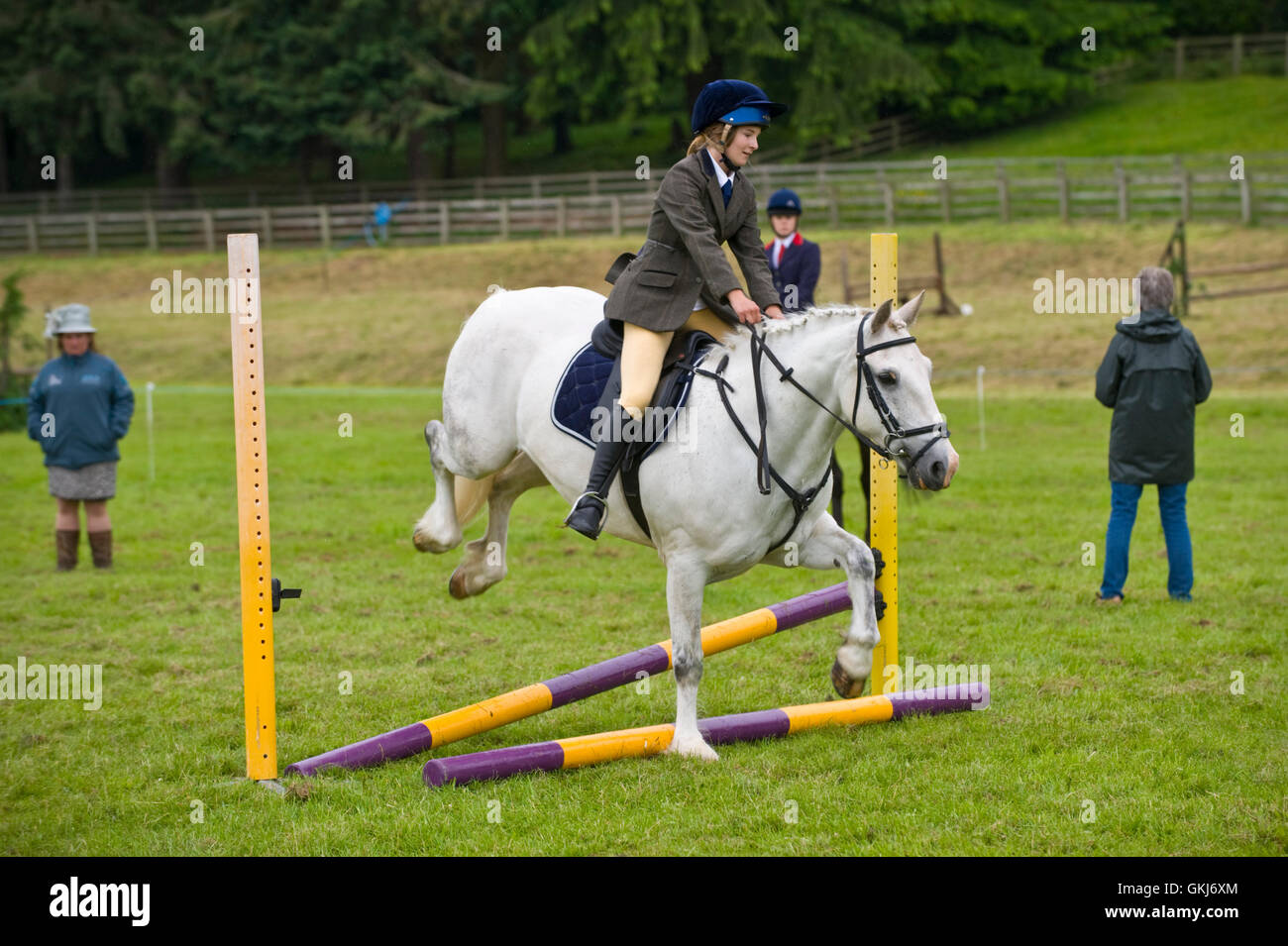 Junges Mädchen & ihr Pony springen Zäune in Golden Valley Ponyclub, Baskerville Hall, Clyro, Powys, Wales, UK Stockfoto