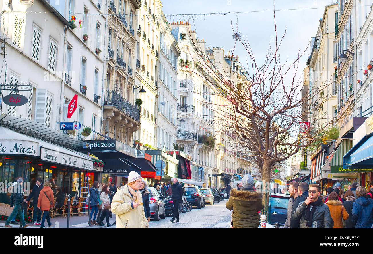 Menschen zu Fuß auf einer Straße in Montmartre. Montmartre ist ein beliebtes Ferienziel in Paris. Stockfoto