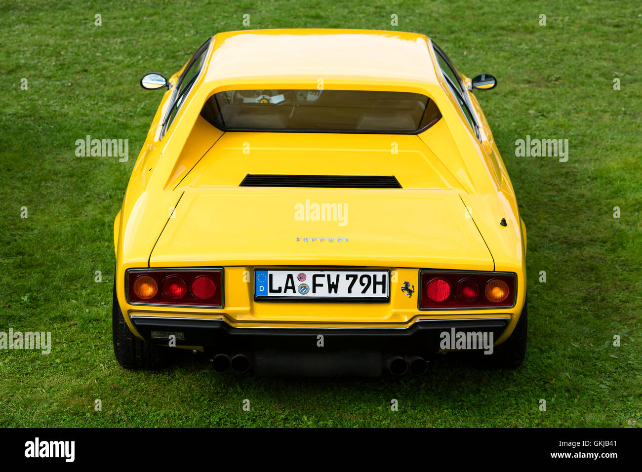 Eine Rückansicht von einem gelben 1975 Ferrari Dino 308 GT4 klassischen Sportwagen geparkt auf dem grünen Rasen Stockfoto