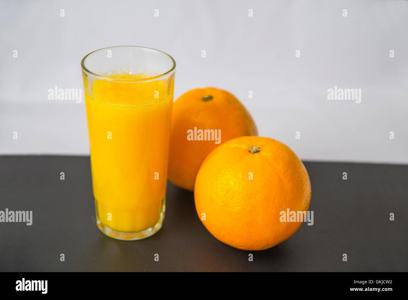 Glas Orangensaft und zwei Orangen. Still-Leben. Stockfoto