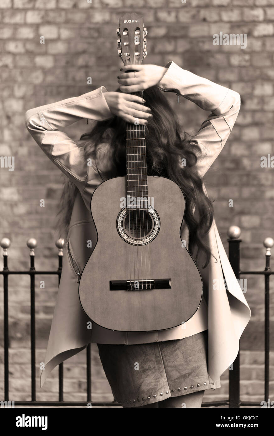 Country-Musik star Performer weiblich, geschossen von hinten, Ziegel-Wand-Hintergrund Stockfoto