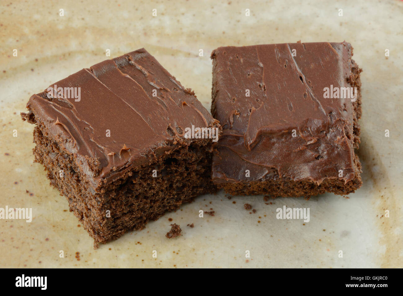 Schokoladenkuchen-Quadrate mit Schokoladenglasur auf Platte Stockfoto