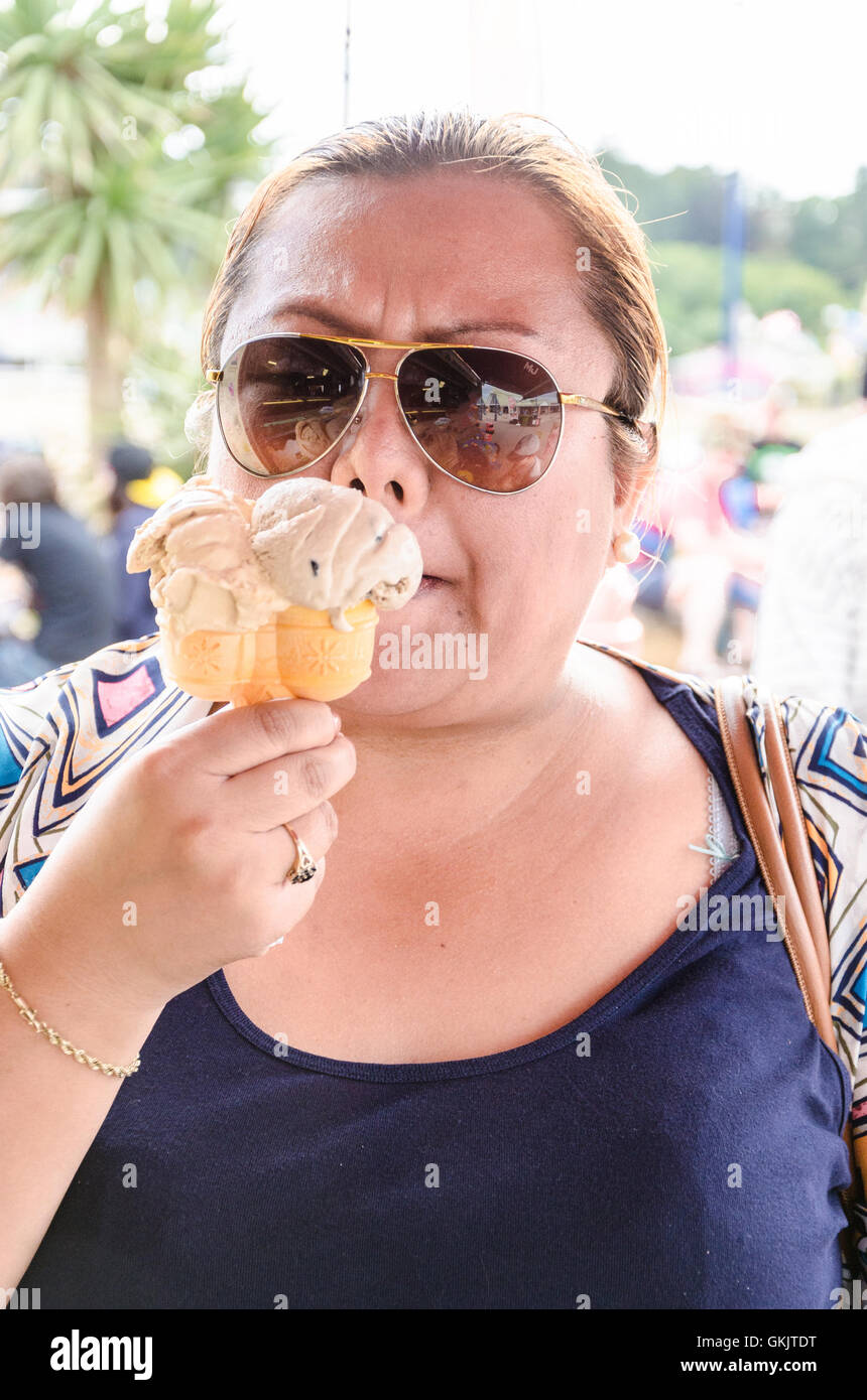 Eine Frau mit Sonnenbrille genießt ein Eis zu essen. Stockfoto