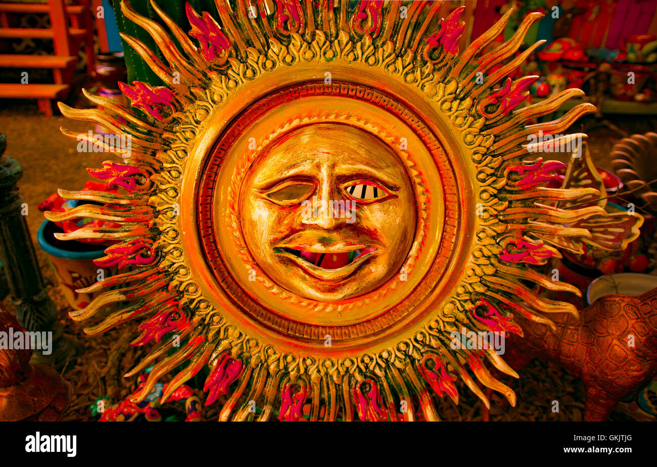 Eine bunt bemalte Metall Sonne Gesicht Skulptur. In einen alten Schrottplatz. Stockfoto