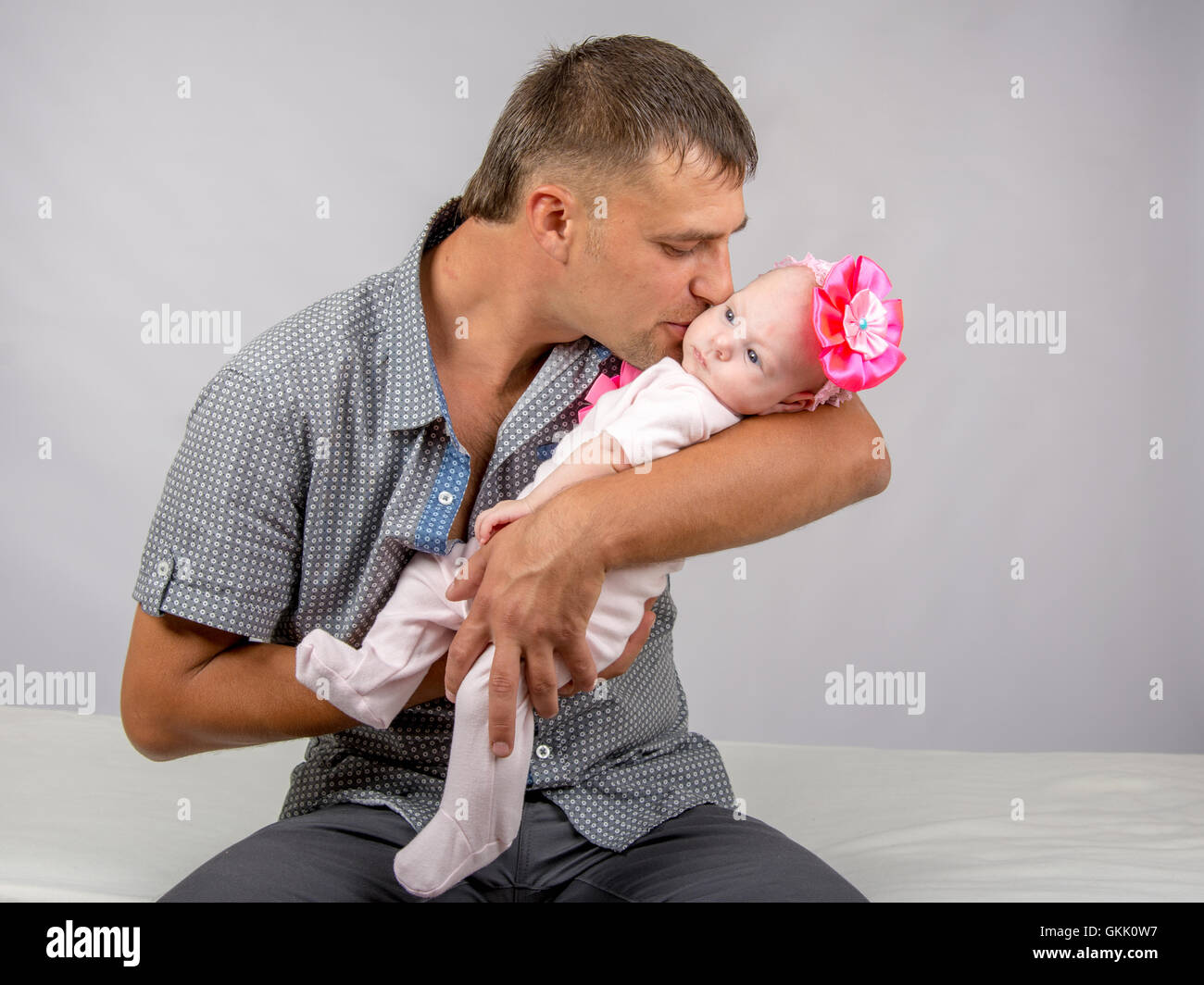 Glücklicher Vater küsst seine Tochter zwei Monate Stockfoto