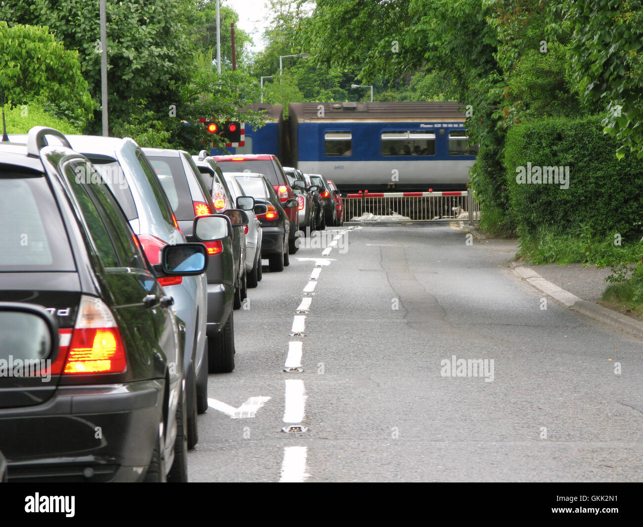 Reihe von Autos warten auf ländlichen Bahnübergang am Tagging-Nordirland Stockfoto