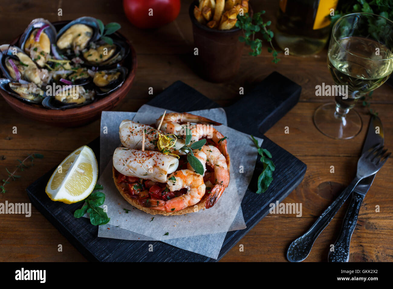 Gegrillte Tintenfische und Srimps mit gedämpfte Muscheln, Pommes Frites und Wein Stockfoto