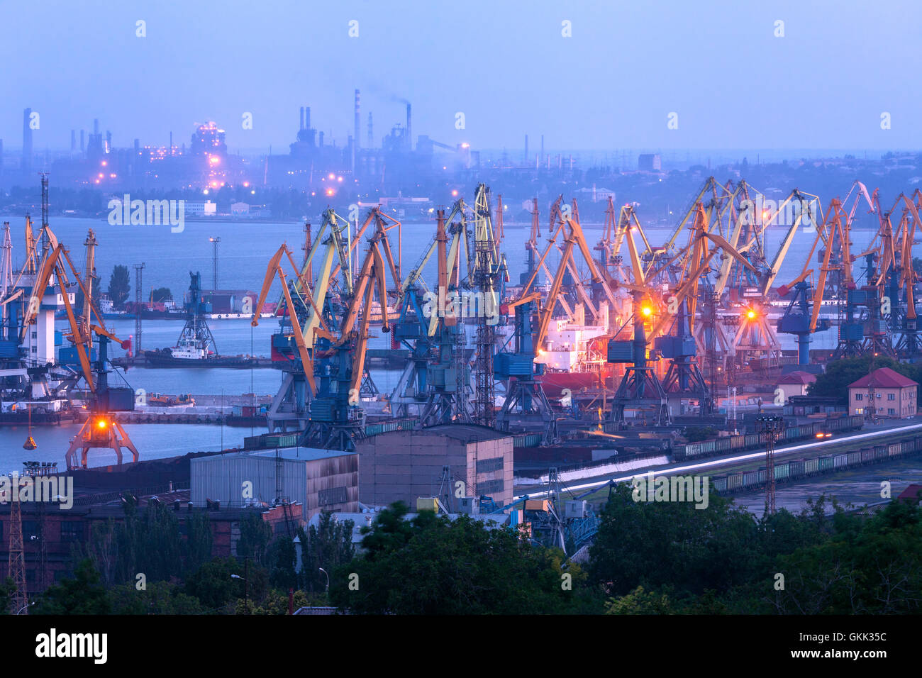 Kommerzielle Seehafen in der Nacht gegen arbeiten Stahlwerk in Mariupol, Ukraine. Industrielandschaft. Fracht-Frachtschiff Stockfoto