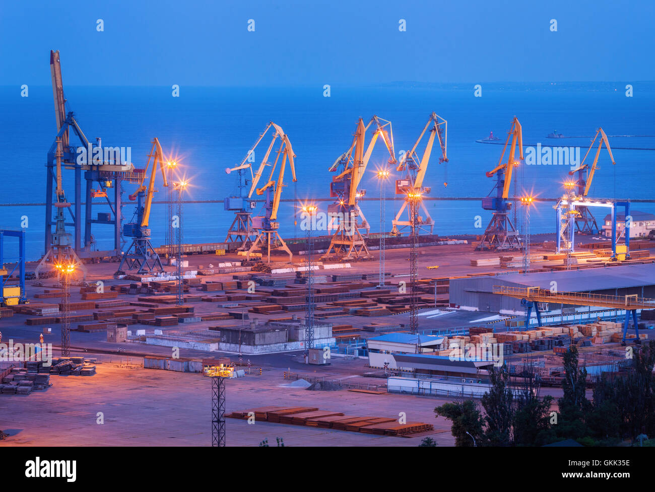 Kommerzielle Seehafen in der Nacht in Mariupol, Ukraine. Industrielandschaft. Fracht Frachtschiff mit Kränen Brücke arbeiten Stockfoto