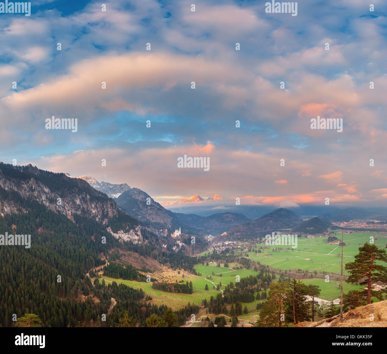 Schöne bunte Panorama-Landschaft mit alpine Berge, Bäume, Wiese, Wolken und blauer Himmel bei Sonnenaufgang im Frühling. Stockfoto