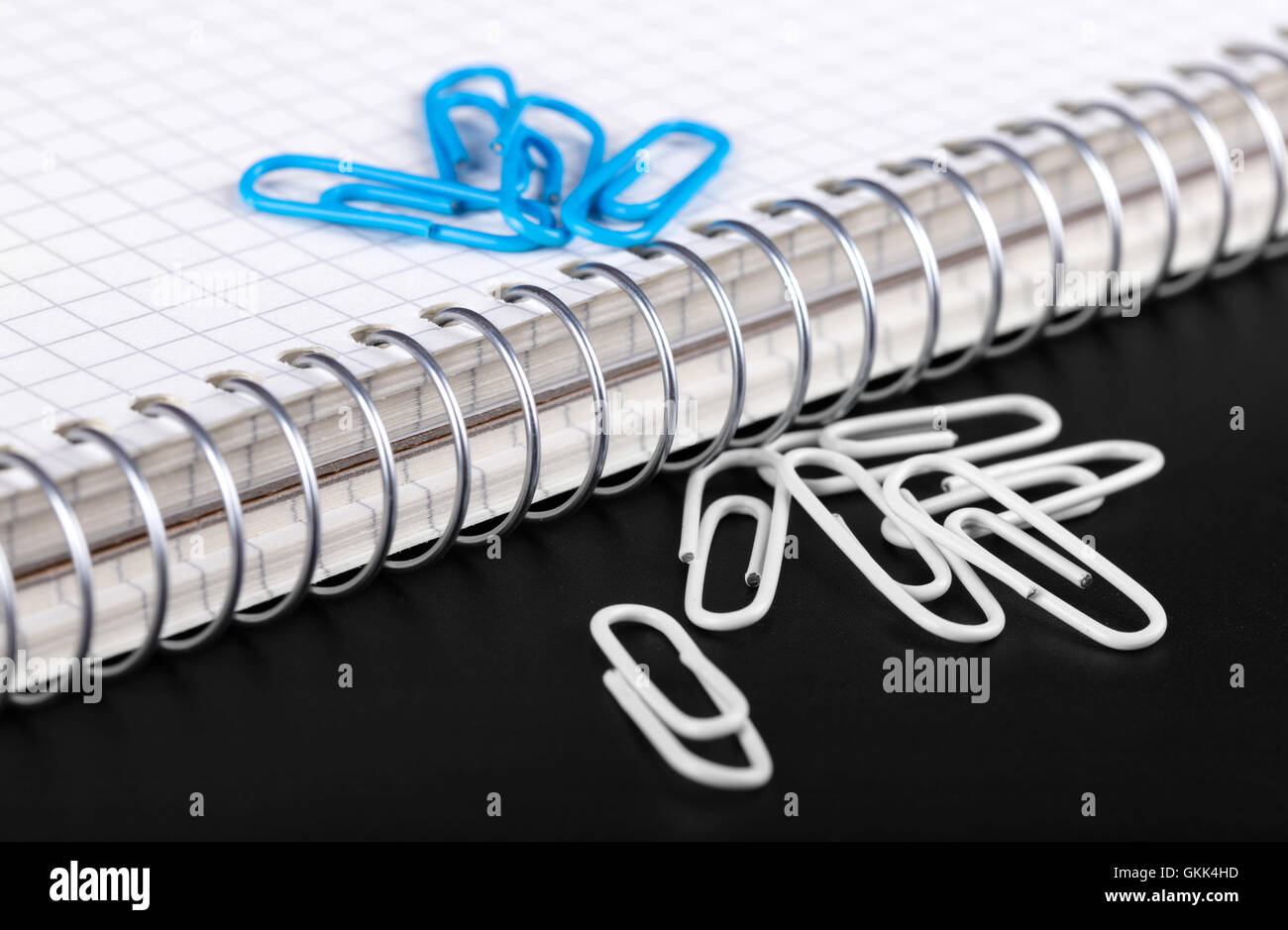 Notebook und Büroklammern Nahaufnahme auf schwarzem Hintergrund Stockfoto