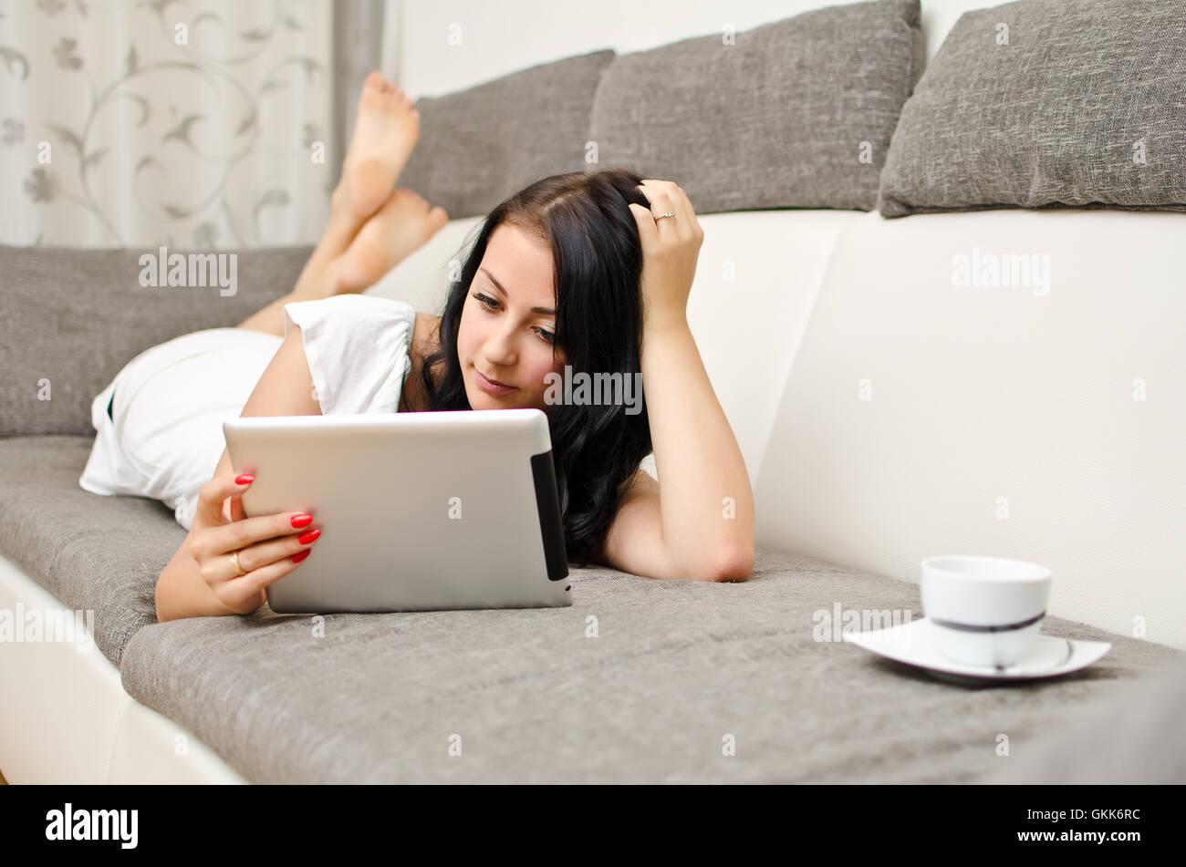 Brünettes Girl mit Tablet-pc auf dem Sofa. Stockfoto