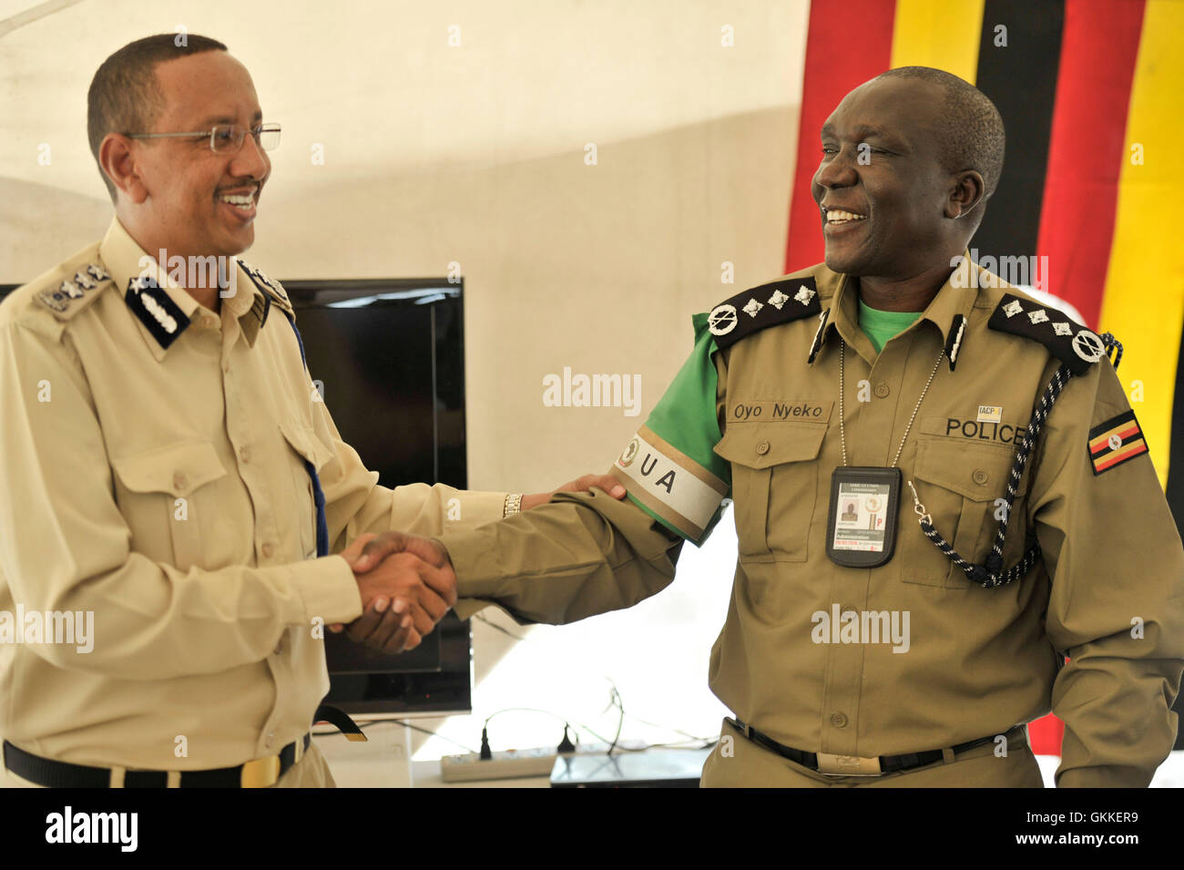 General Abdihakim Saacid, der somalische Polizeikommissar, und der amISOM-stellvertretende Polizeikommissar Benson Oyo-Nyeko tauschen sich während einer Medaillenverleihung am 9. Juli 2014 im Mogadischu-Stadion an die aus Uganda gebildeten Polizeieinheiten aus. 138 Offiziere wurden für ihren Dienst anerkannt. Stockfoto