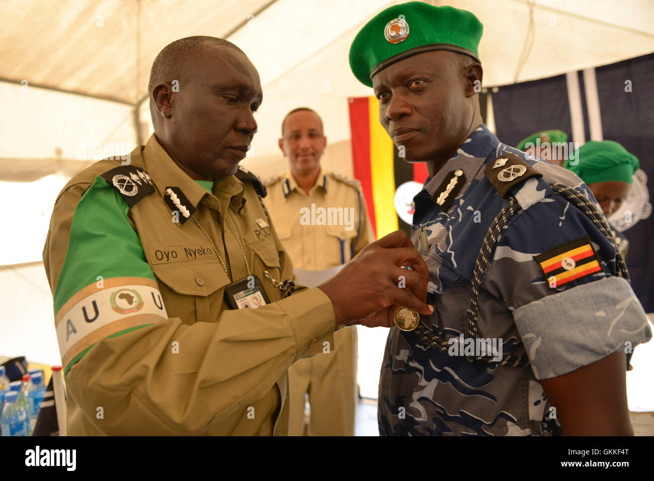 Der stellvertretende Polizeikommissar der AMISOM Benson Oyo-Nyeko vergibt am 9. Juli 2014 im Mogadischu-Stadion Medaillen an den Befehlshaber der ugandischen Polizeieinheit (FPU) Christopher Kasalawo und 137 weitere Polizeibeamte. Die Zeremonie war der Abschluss ihrer Mission in Somalia. AMISOM Photo / David Mutua. Stockfoto