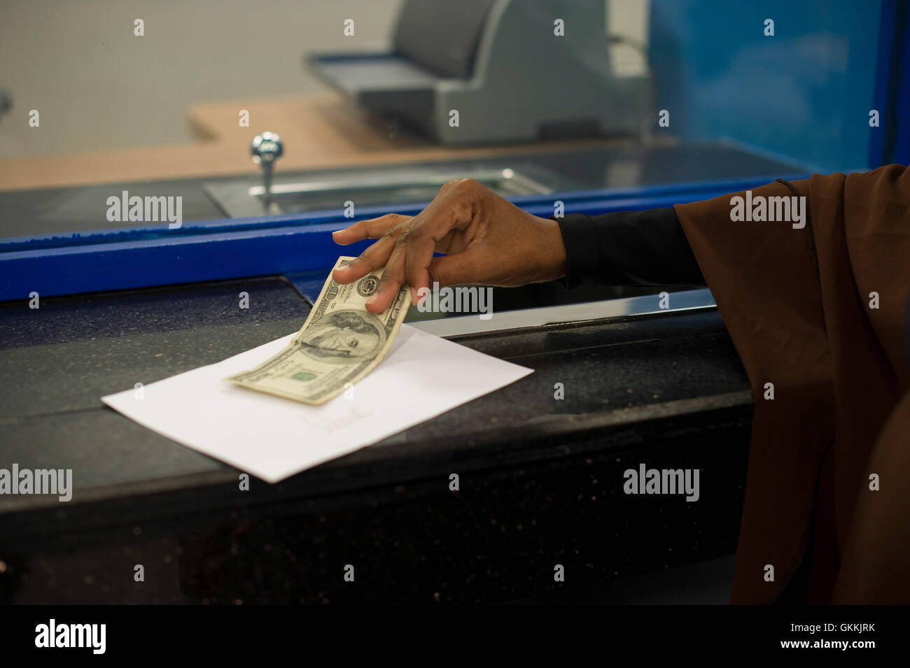 Am 21. Mai 2015 wurde die Premier Bank offiziell in Mogadischu eröffnet, was einen Meilenstein in der Erholung des somalischen Finanzsektors darstellt. Ein Kunde erhält während der Veranstaltung 100 US-Dollar von einem Kassierer, was das wachsende Vertrauen in somalische Banken symbolisiert. AMISOM Photo / Omar Abdisalam. Stockfoto