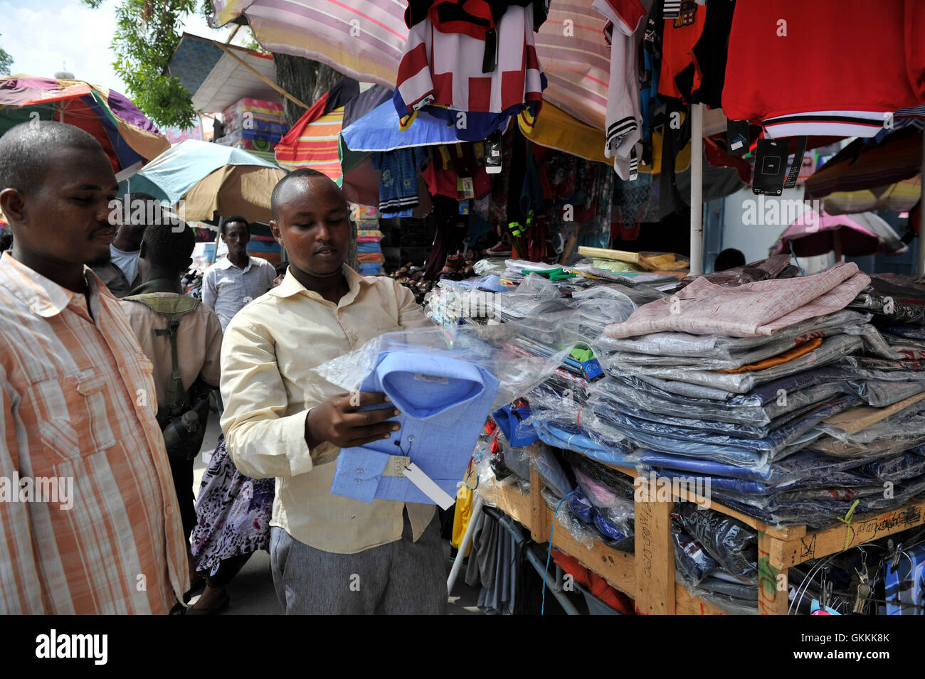 Am 16. Juni 2015 kauft ein somalischer Mann ein Hemd bei einem Straßenverkäufer in Mogadischu, als die Vorbereitungen für den heiligen Monat Ramadan beginnen. Ramadan ist eine bedeutende Zeit für Muslime auf der ganzen Welt. Foto von Omar Abdisalan. Stockfoto