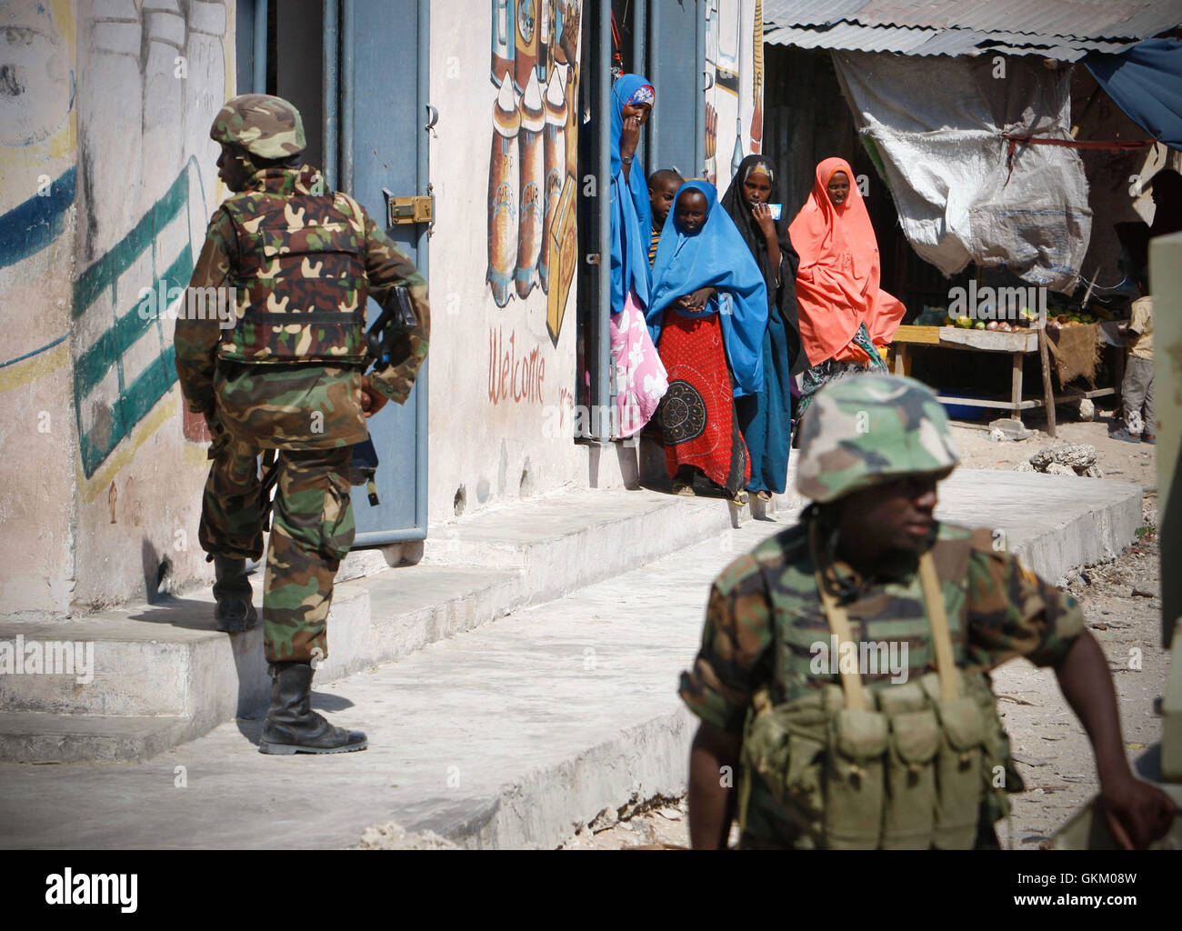 SOMALIA, Mogadischu: Auf einem Foto genommen 5 Dez und veröffentlicht durch die hybride Nationen Informationen Support Team 8 Dec, Somalische Frauen Blick auf als ugandische Soldaten dienen mit der Mission der Afrikanischen Union in Somalia (AMISOM) defensive Positionen einnehmen in Torfiq Markt im Bezirk Yaaqshid der nördlichen Mogadischu. Angesichts einer Welle von Auto angreift Bombenanschläge und improvisierten Sprengkörpern (IED), die 9.700 starke Afrikanische Union weiterhin geltenden Sicherheits-und Counter-IED Vorgänge in und um der somalischen Hauptstadt. AU-UN IST FOTO / STUART PRICE. Stockfoto