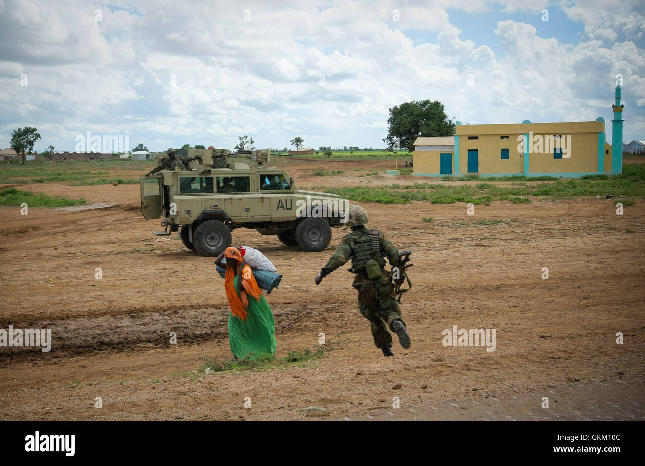 SOMALIA, Afgoye: Auf einem Foto von der hybride Nationen Informationen Support Team 25 Mai veröffentlicht, führt ein ugandischer Soldat dienen mit der Mission der Afrikanischen Union in Somalia (AMISOM) vorbei eine somalische Frau gegenüber seine Kampffahrzeug nahe dem Zentrum von Afgoye Stadt im Westen von der somalischen Hauptstadt Mogadischu. AMISOM und Somali National Army (SNA) Truppen fegte durch Afgoye ohne einen Schuss heute, Befreiung von der Gegend und seiner Bevölkerung - darunter 400.000 intern Vertriebene - von der Kontrolle von der Al-Qaeda angeschlossene Extremistengruppe Al Shabaab. AU-UN IST FOTO STUAR Stockfoto