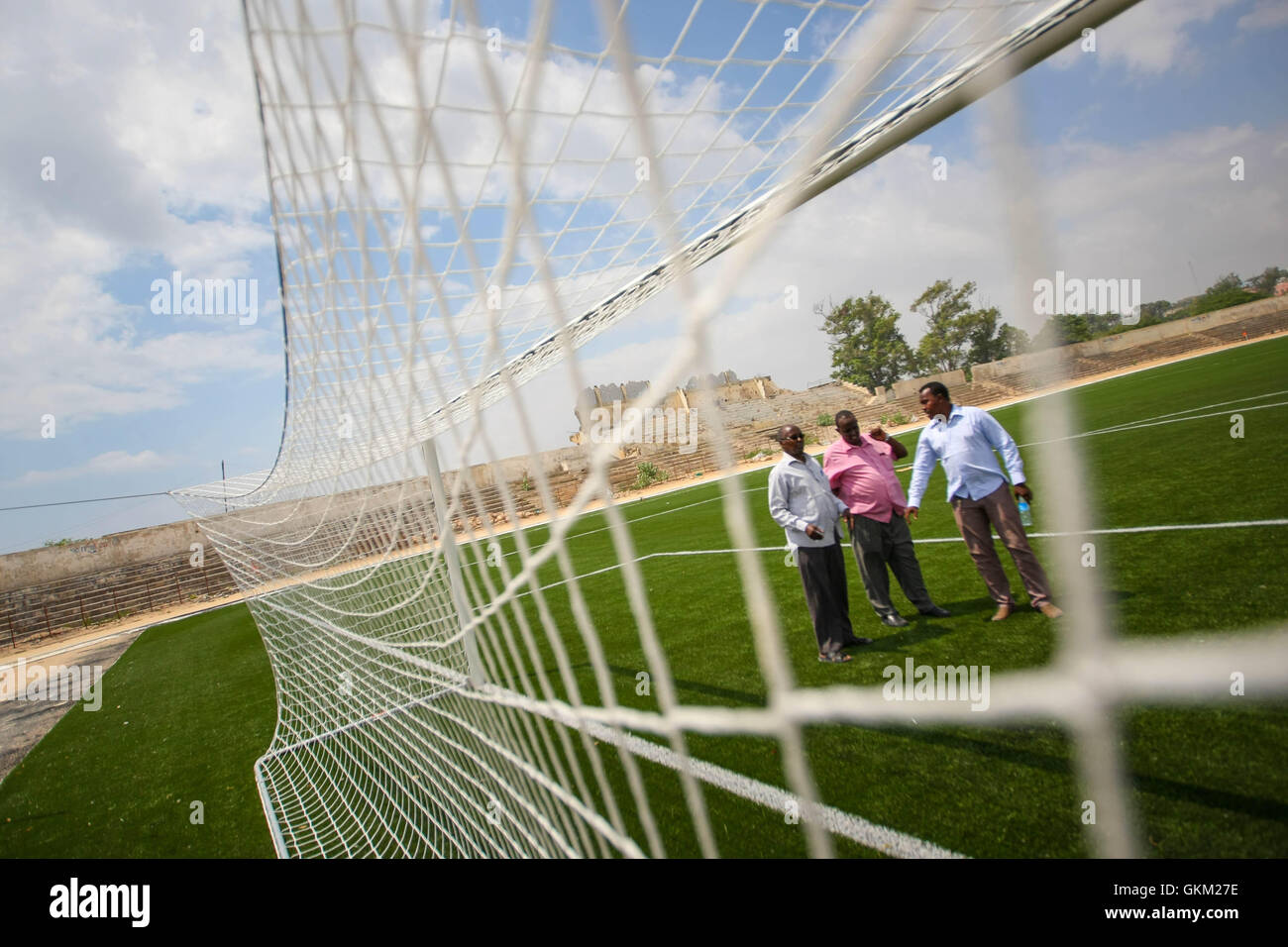 SOMALIA, Mogadischu: Ein Handout Foto vom 12 Januar und veröffentlicht von der hybride Nationen Informationen Support Team 16 Januar zeigt Mitglieder des somalischen Fußball Föderation (SFF) stehen vor ein Ziel-Mund im Baanadir-Stadion im Stadtteil Abd-Aziz von der somalischen Hauptstadt Mogadischu, die vor kurzem mit einer neuen künstlichen Spielfläche wurden wieder aufgetaucht. Finanziert von der FIFA, die FSF hat die 7.500-fassende Stadion neu begrünt und wird in Kürze beginnen Reparaturarbeiten an Plätze, Parkplätze und andere Einrichtungen, die derzeit mit Erinnerungen an Somalia Krieg heimgesuchten Vergangenheit gespickt sind. Stockfoto