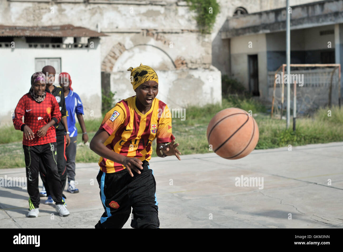 Am 6. Juni übergibt ein Mädchen einen Ball während einer Basketballübung in Mogadischu, Somalia. Nachdem der Basketball von der extremistischen Gruppe Al Shabaab verboten wurde, gewinnt er in der Stadt wieder an Popularität. Derzeit gibt es mindestens ein Dutzend Teams, an denen sowohl Männer als auch Frauen aktiv teilnehmen. Das Wiederaufleben spiegelt das wachsende Interesse am Sport in Mogadischu wider. Foto von Tobin Jones. Stockfoto