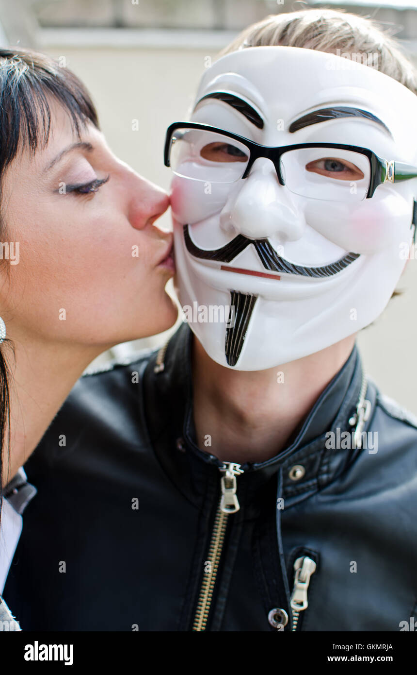 Frau Mann in Vendetta Maske in Gläsern zu küssen. Stockfoto