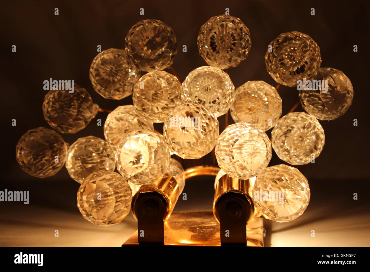 Wandleuchten mit Kugel Kristalle hängt, fotografiert von unten, gelbes Licht eingeschaltet Stockfoto