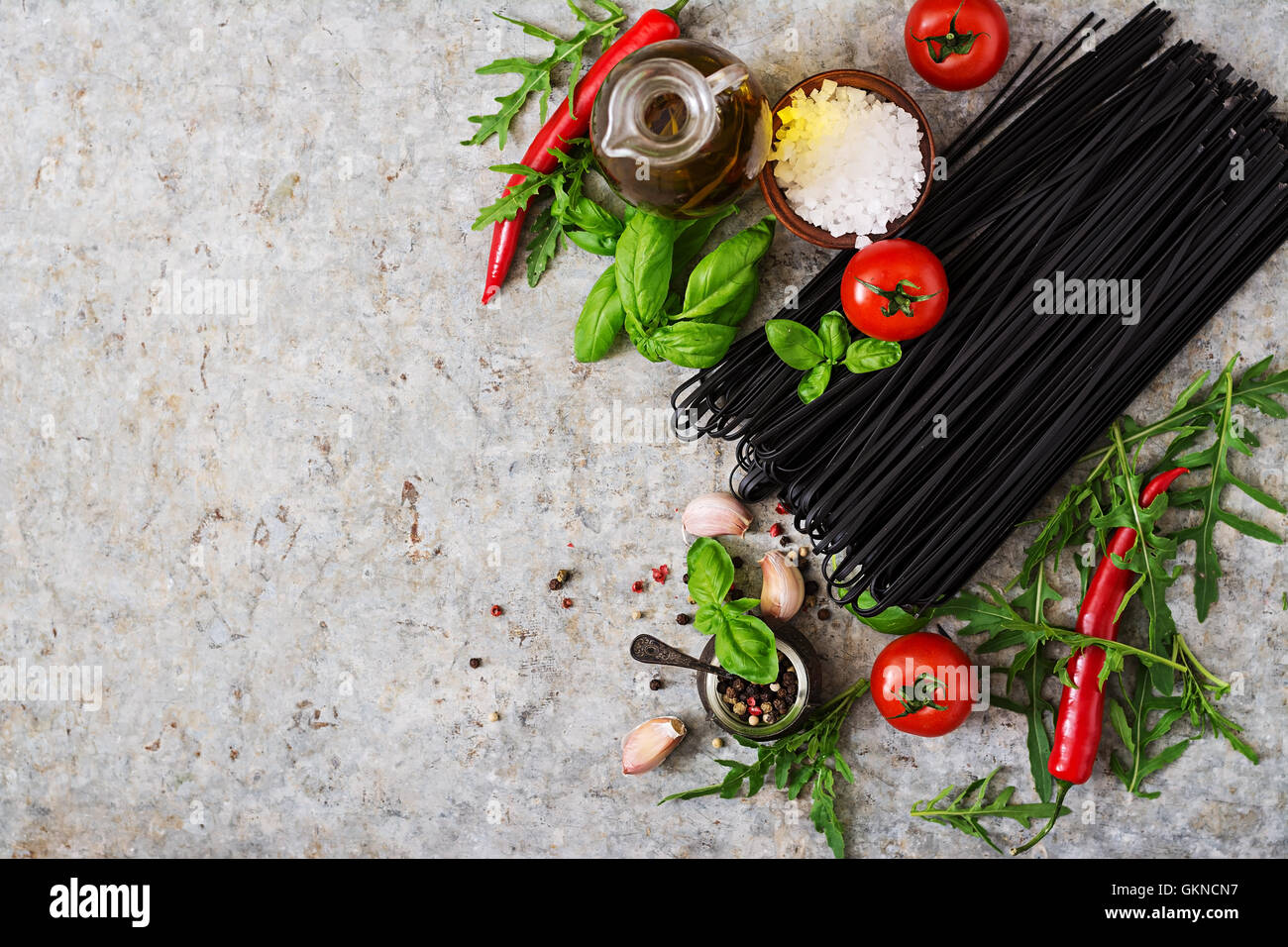 Zutaten für schwarze Linguine Pasta - Tomate, Basilikum, Chili. Ansicht von oben Stockfoto
